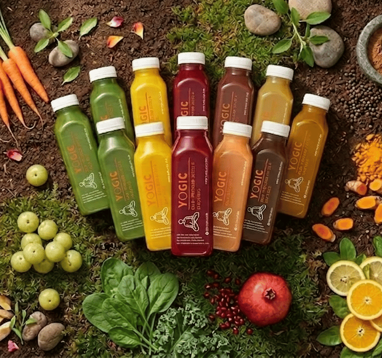 Yogic cold-pressed juices surrounded by fresh fruits, vegetables, and herbal powders on soil.