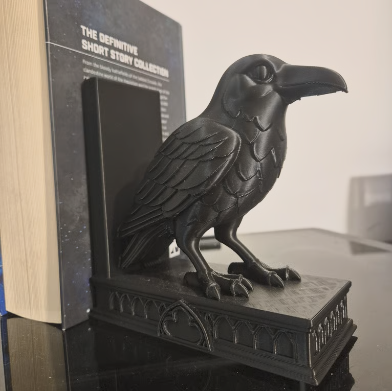 Serre-livres corbeau noir imprimé en 3D soutenant un livre sur une étagère