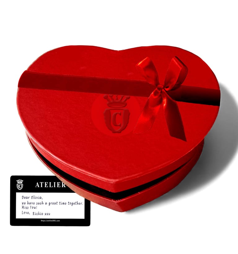 Red heart-shaped gift box with a satin bow and a personalized Atelier note.