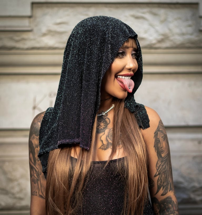 Model in black hooded outfit posing for street fashion shoot by Fred Art Studio.