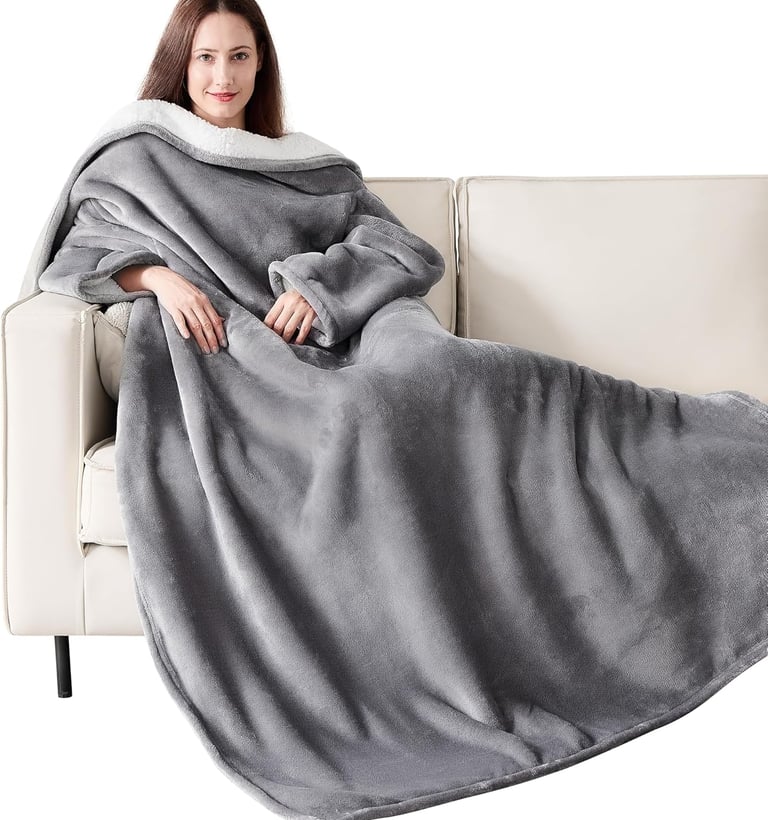 a woman sitting on a couch with a blanket on it