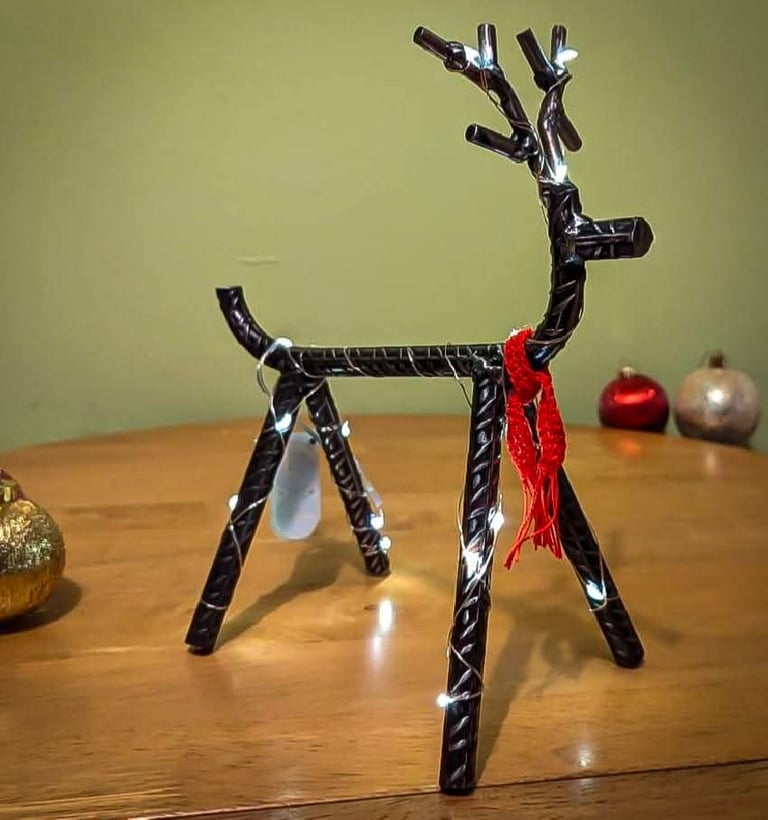 Seasonal designs as represented by a reindeer made from metal rebar, with fairy lights and a scarf