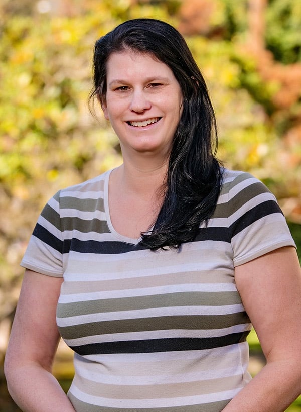 Image of Michelle smiling against background of yellow fall leaves
