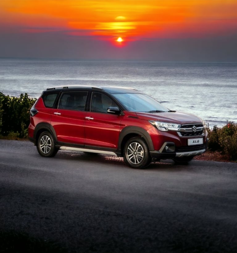 a red Suzuki xl6 parked on a road near the ocean