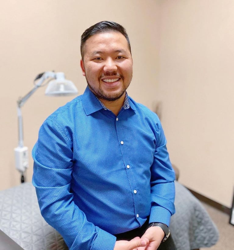Dr. Xiong in a blue button-down shirt at Balance Naturopathic & Acupuncture Clinic.