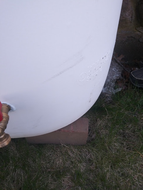 A Rain Barrel been leveled on bricks to insure it does not tip over.