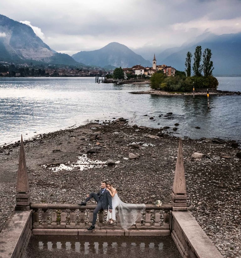 a couple sitting on a bench in front of a lake