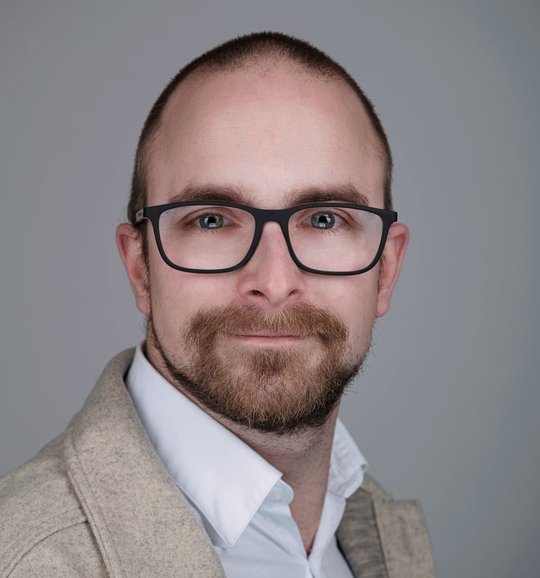 portrait of a man with a beard and glasses on his face