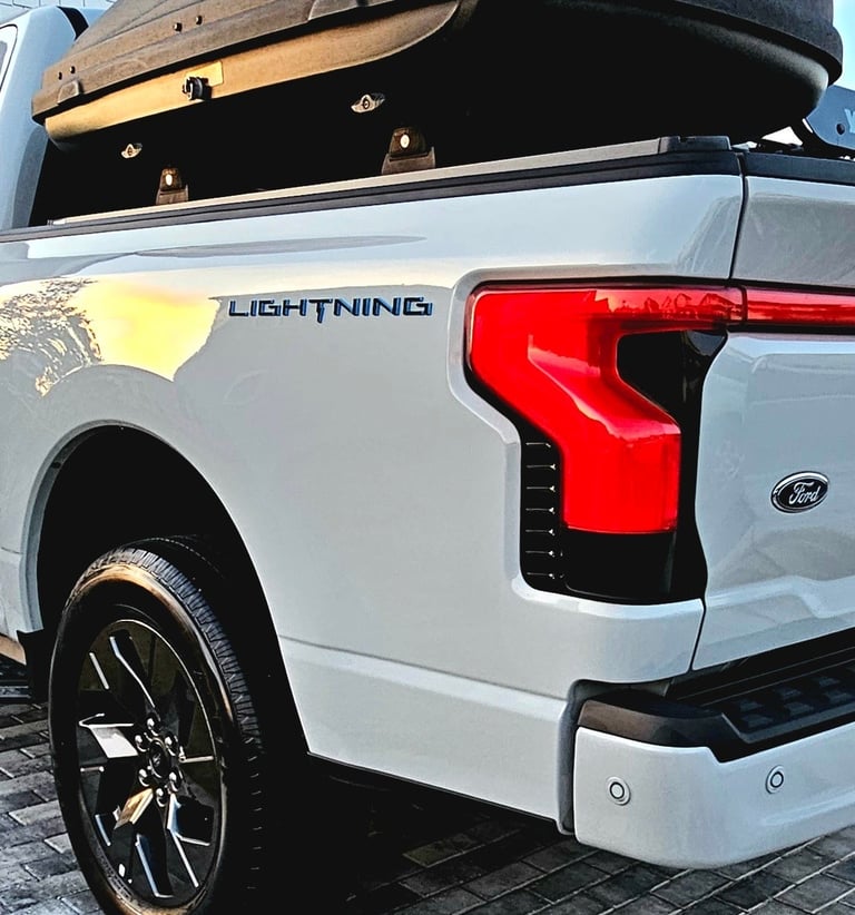 a white truck with a black roof and a luggage case