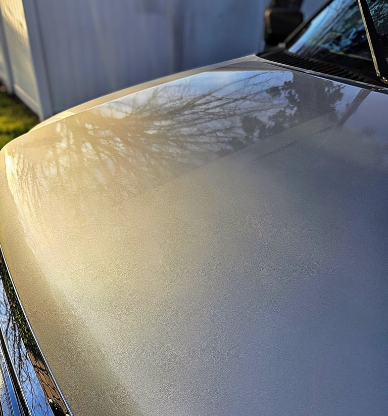 A truck hood showing polishing paint correction results