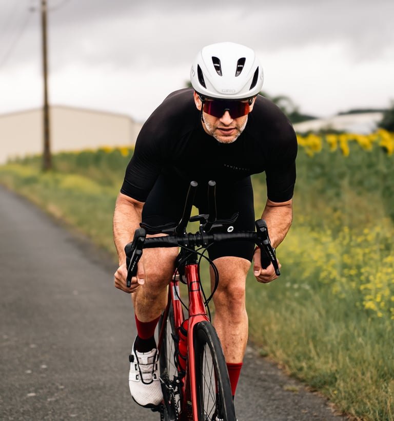 Cycliste en plein effort sur une route de campagne, photographie sportive à l’approche documentaire