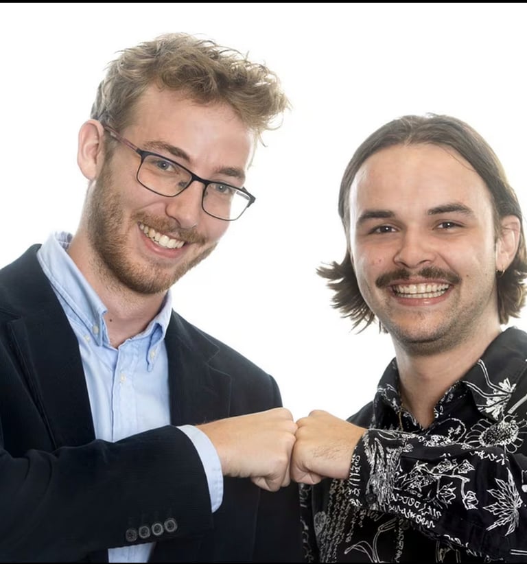 a man in a suit and tie is smiling and pointing at the camera