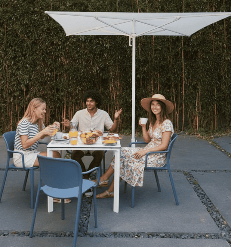 Espacio corporativo de bienestar con sillones, plantas y personas trabajando en pausa.