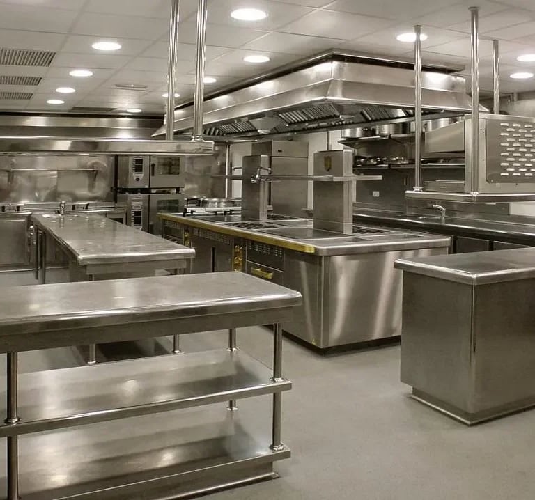 Complete stainless steel kitchen fit-out with custom work benches and exhaust hoods by the About SSB team.
