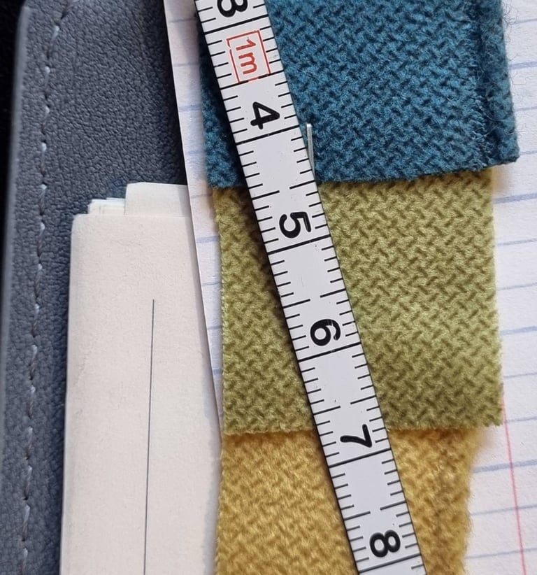 Užuolaidų atkirpti audiniai ir matavimo juosta