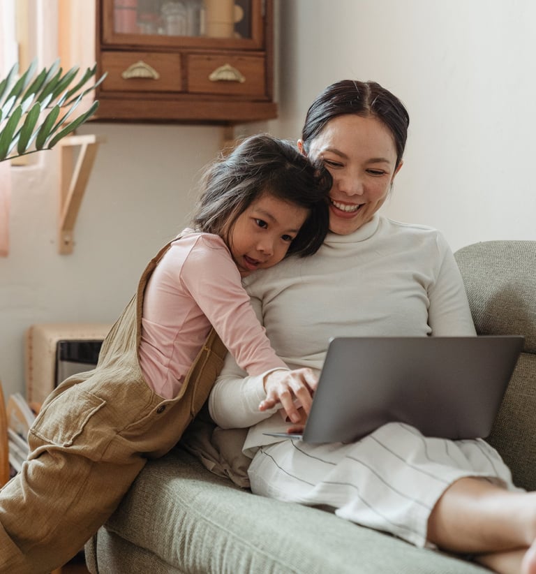 a woman and her daughter sitting on a couch