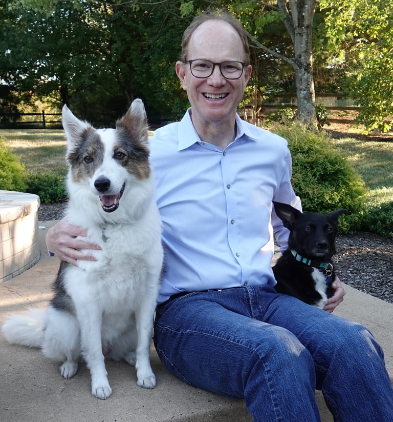 Photo of Michael Rabinowitz with his two dogs in backyard