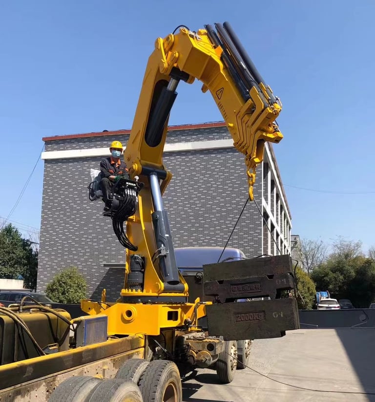 A large object being raised by a crane, specifically a 25 Ton Knuckle Loader Crane.