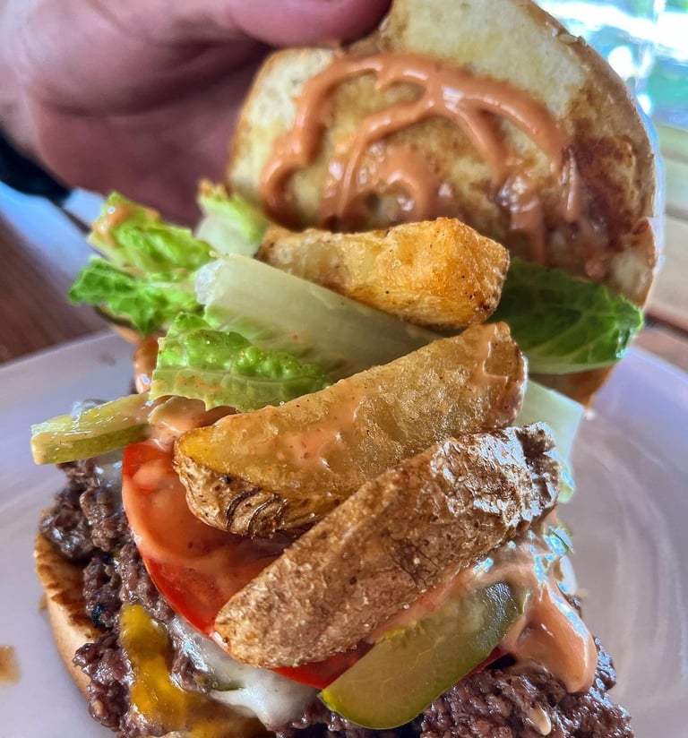 Burger with fresh ingredients and french fries at Barrel Bar & Grill restaurant