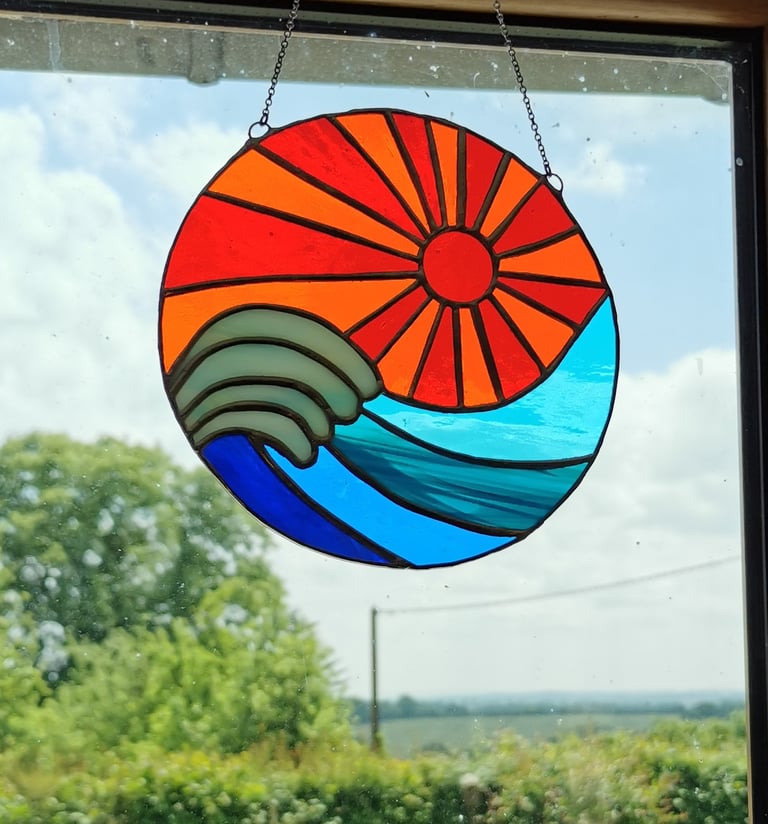 a sun catcher with a sun shining through the window