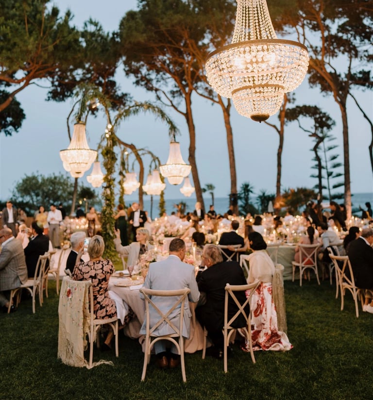 Elegant outdoor dinner at Villa El Rincon with chandeliers and guests under the trees