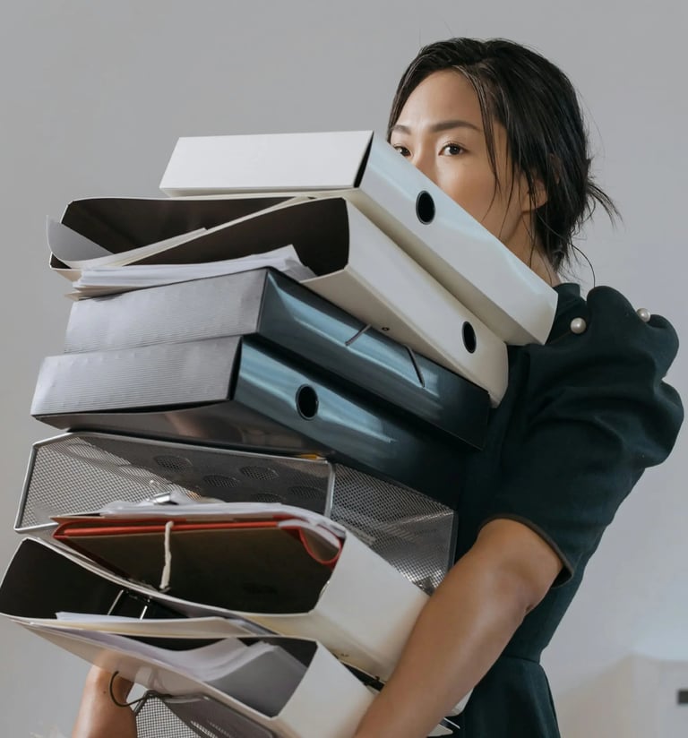Mujer cargando folios y carpetas con documentos de aduana.