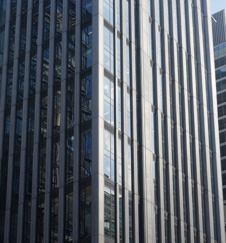 Cool corporate architecture of a financial district, glass and steel skyscraper facades reflecting crisp daylight, deep navy and silver tones, sharp focus, 35mm