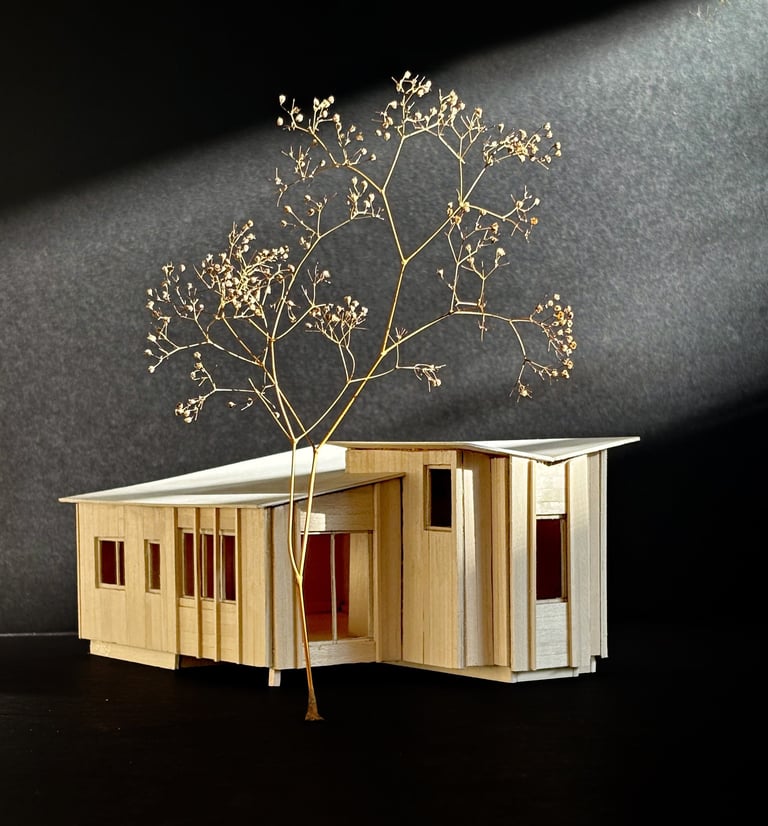 Handcrafted basswood architectural model of a modern cabin design against a dark background.