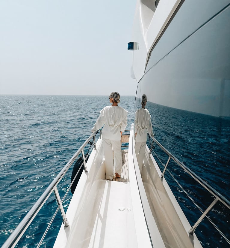 Девушка в белом смотрит на спокойное море с борта моторной яхты, аренда чхт