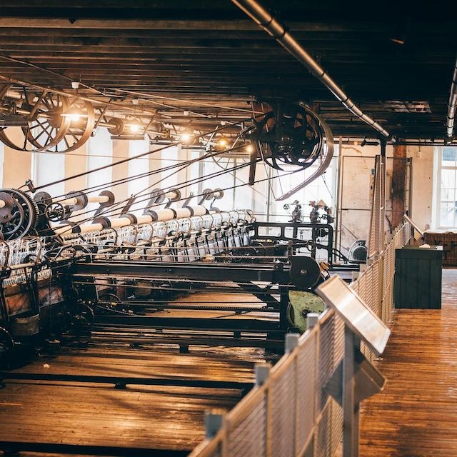 A large number of old weaving machines in a mill