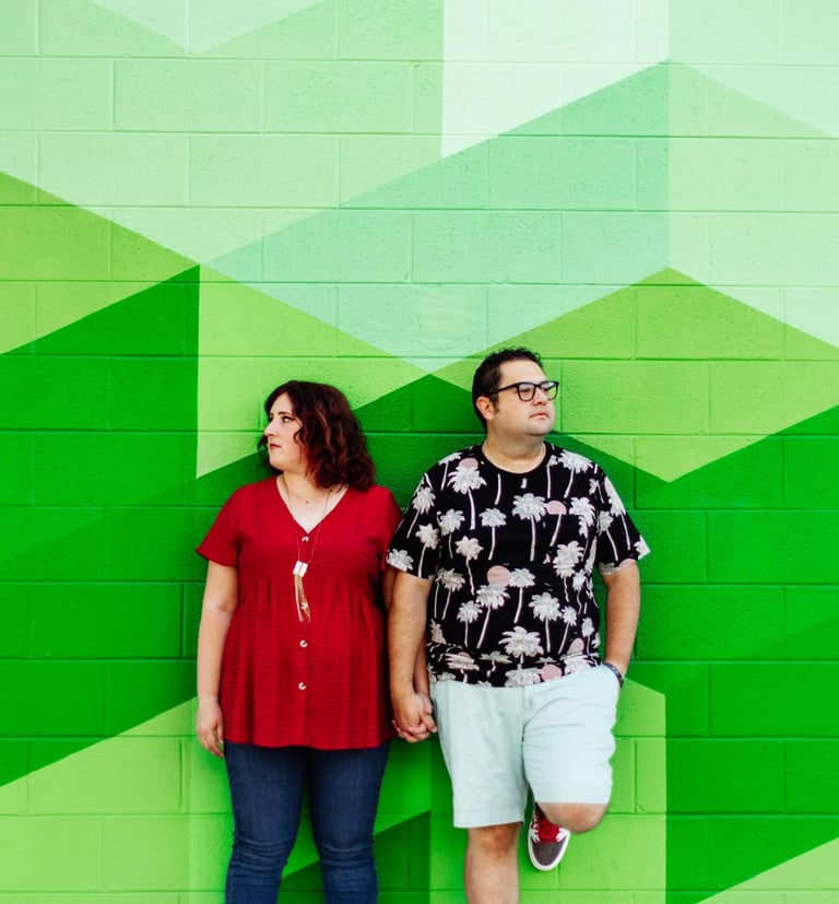Alamosa Consulting founders man and woman pose in front of a mural