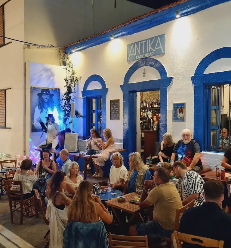 a group of people sitting at tables outside