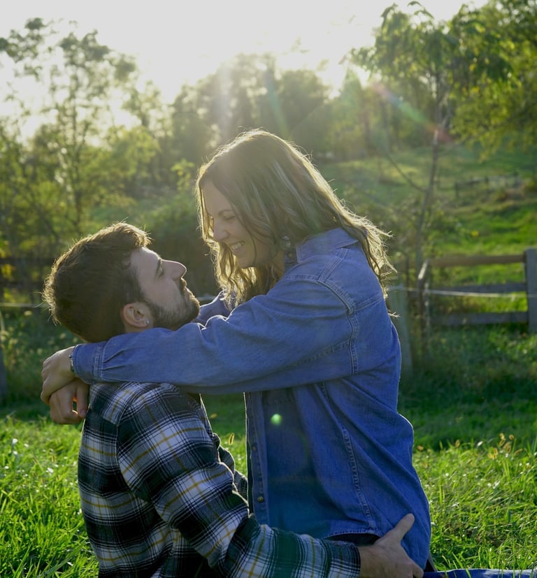 a man and woman sitting on the grass