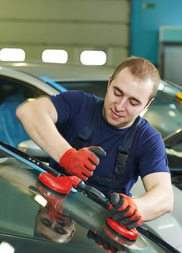 a man in a blue shirt is using a machine to polish a car