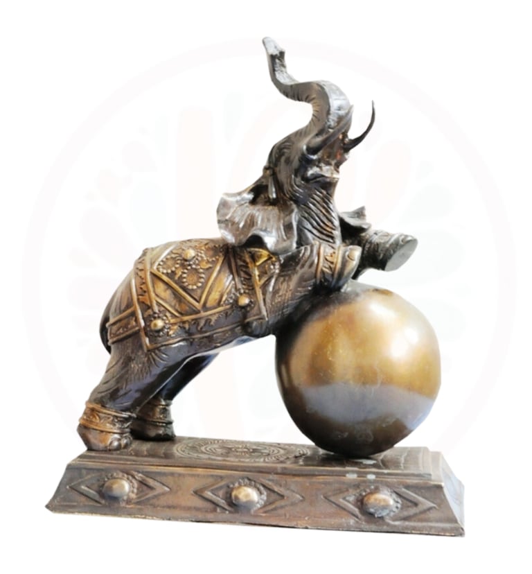 a statue of a man riding a elephant on a ball