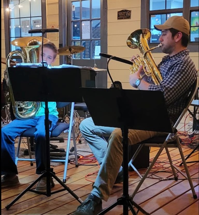 young boy and his teacher playing trombone one stage