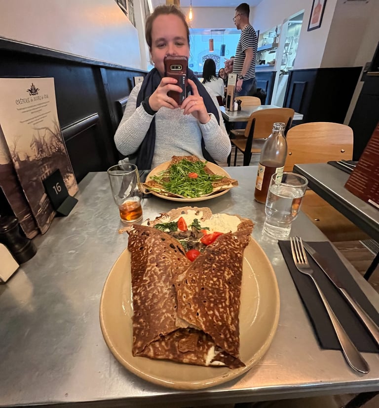 Corinne from Hidden Switzerland Travel taking a photo of a crepe at Creperie du Bourg-de-Four