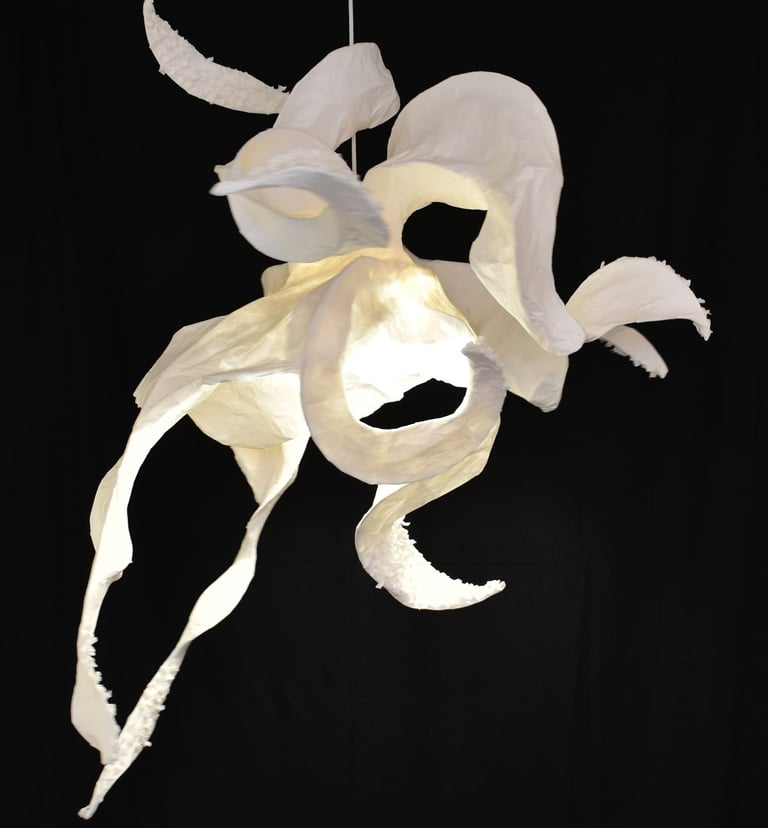 a white paper flower hanging from a string