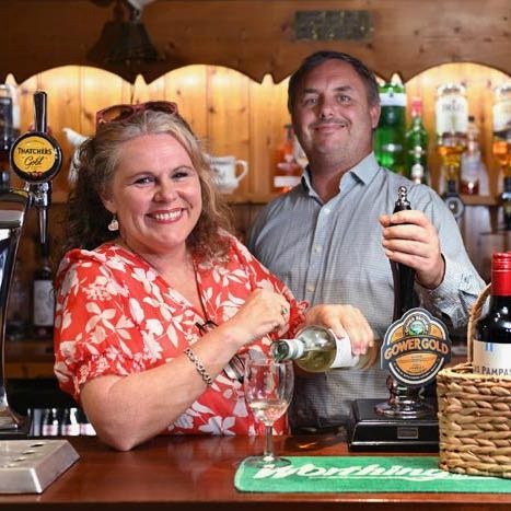 a man and woman standing at a bar