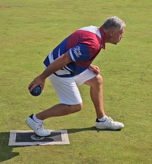 A porthcawl bowls club player in the process of releasing his bowl