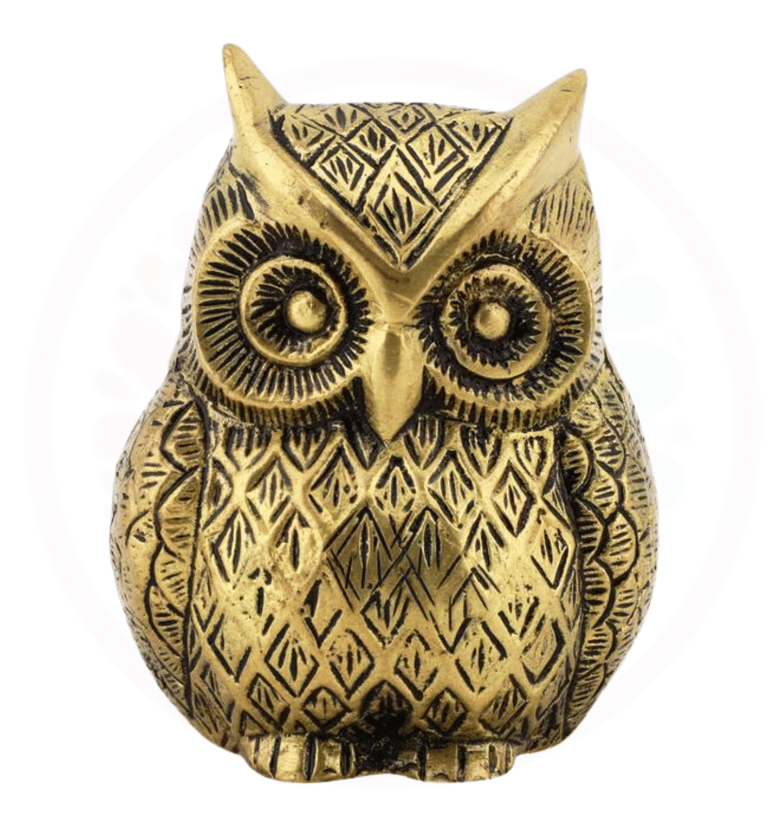 a gold owl figurine with a black and white background