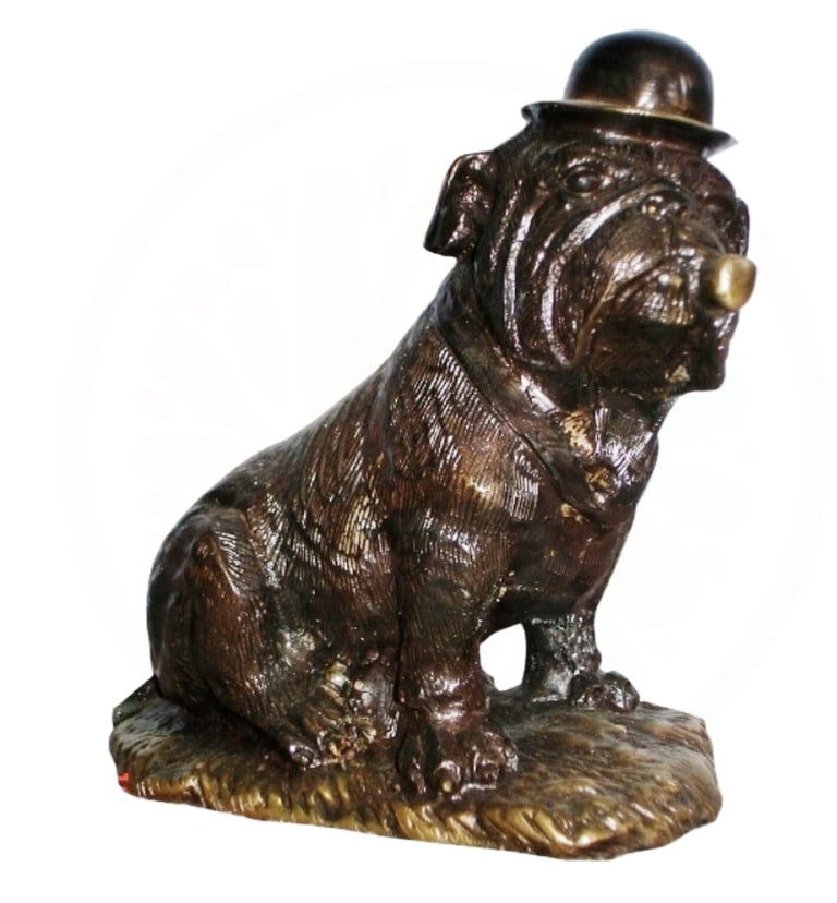 a statue of a brass dog sitting on a rock