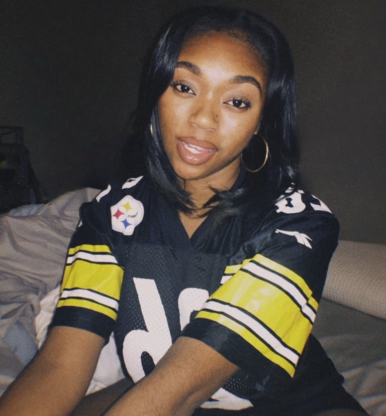 a woman in a football jersey is posing for a picture