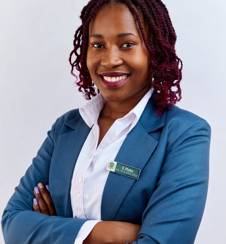 Smiling female professional with red locs wearing a blue business suit and name tag.