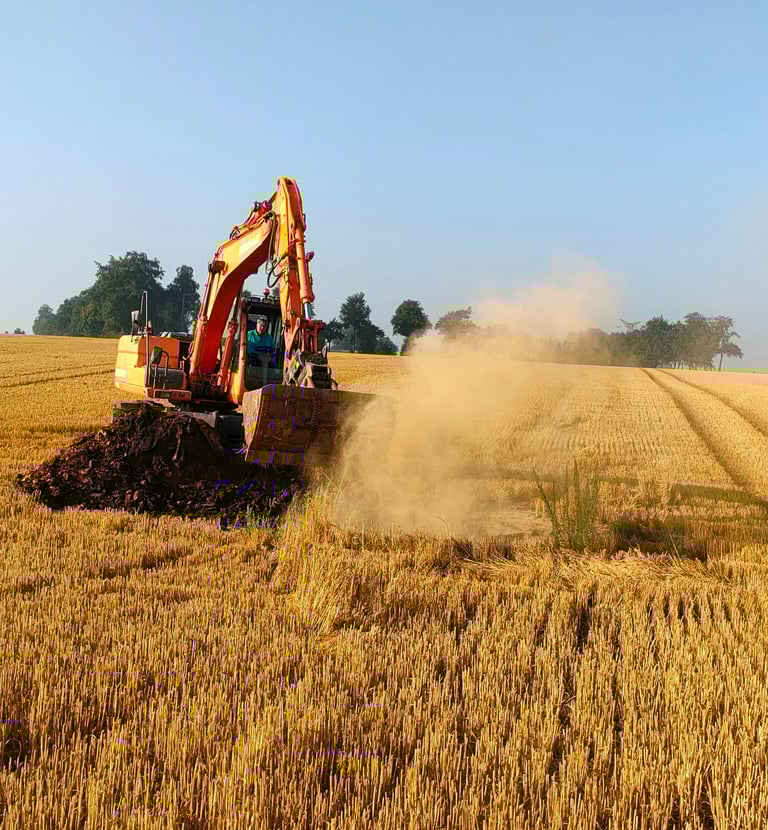 un pelleteur en plein décapage dans un champ pour trouver un puit de marnière
