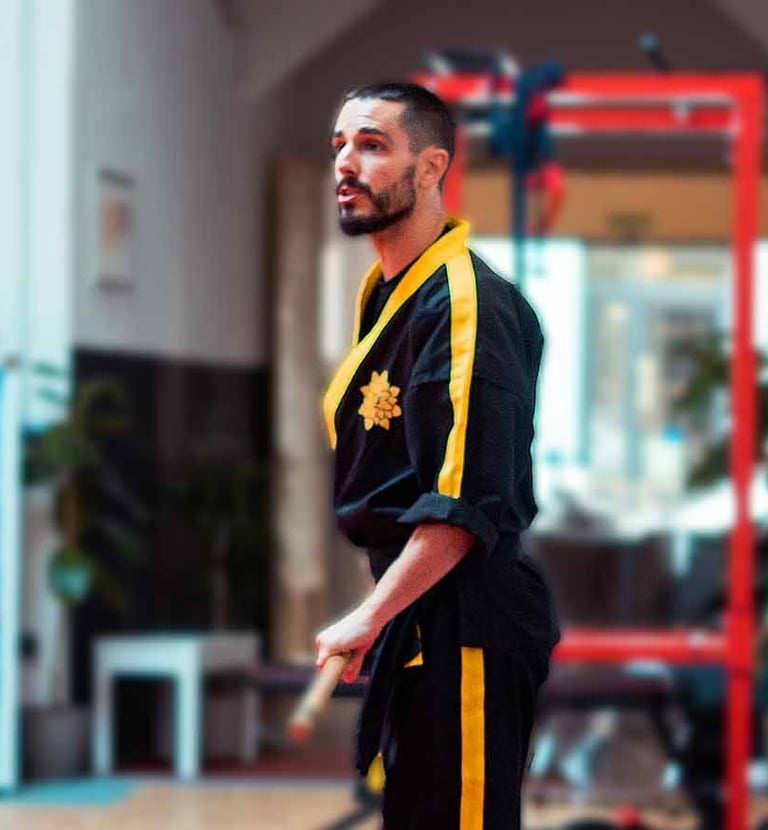 a man in a black and yellow uniform standing on a pink carpet