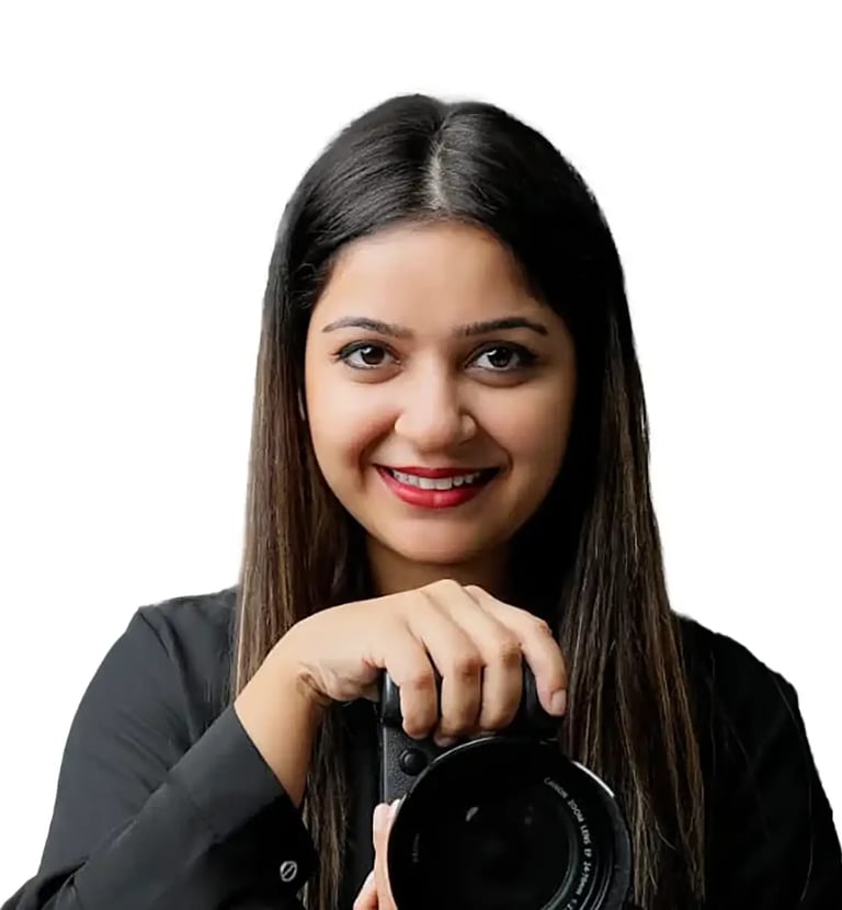 Huma Photographer - a woman holding a camera and smiling