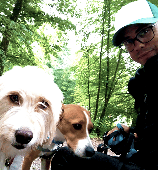 Foto von einem Mann mit zwei Hunden im Wald