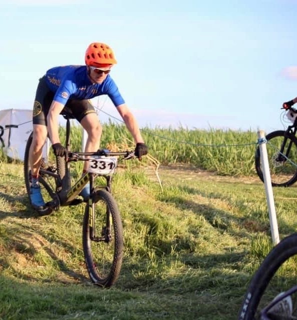 a man riding a bike on a grassy hill