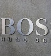 a man in a suit and tie is standing in front of a wall with the